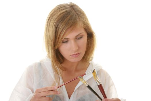 A female blond artist in white uniform with brushes - painting