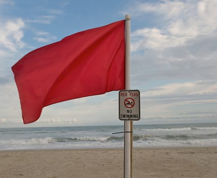 Red warning flag at the beach put up to warn swimmers of strong undertow due to a hurricane out at sea.  