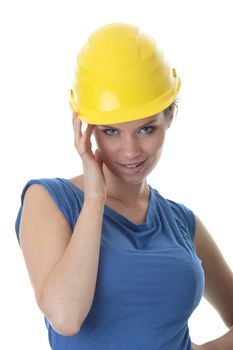 Young female architect or builder wearing a yellow hart hat on a construction site