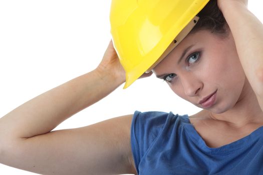 Young female architect or builder wearing a yellow hart hat on a construction site