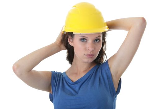 Young female architect or builder wearing a yellow hart hat on a construction site