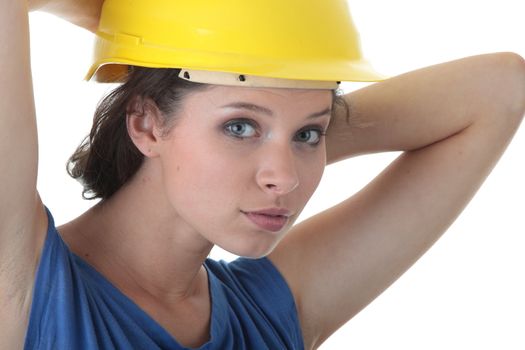 Young female architect or builder wearing a yellow hart hat on a construction site