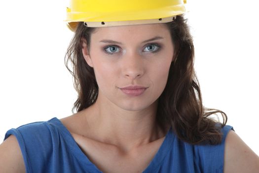 Young female architect or builder wearing a yellow hart hat on a construction site