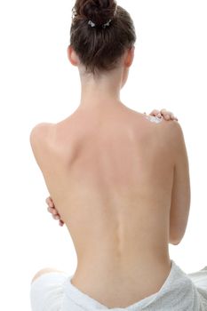 Skincare concept: back of beautiful nude woman with soft skin putting skincare product (cream) on her back