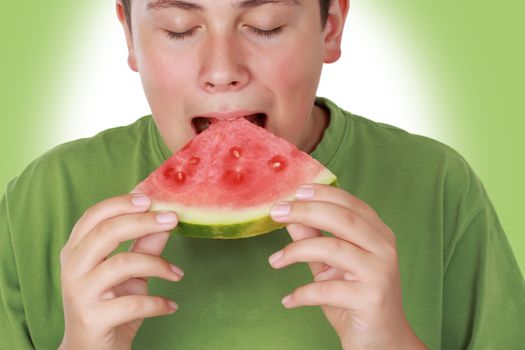 teen boy eating a piece of fresh watermelon