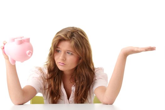 Young beautiful woman siting at the desk with piggy bank (money box), isolated on white background