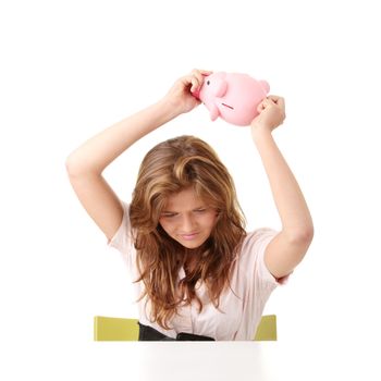 Young beautiful woman siting at the desk with piggy bank (money box), isolated on white background