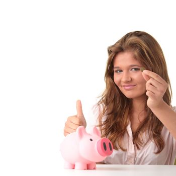 Young beautiful woman siting at the desk with piggy bank (money box), isolated on white background