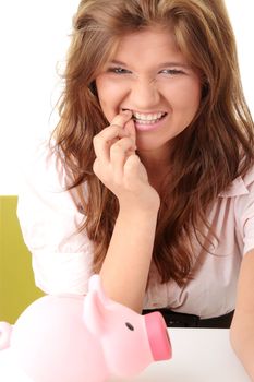 Young beautiful woman siting at the desk with piggy bank (money box), isolated on white background