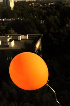 Orange balloon, housing development in the background.