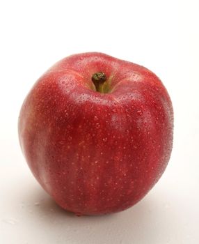 fresh red apple with water drops on white background
