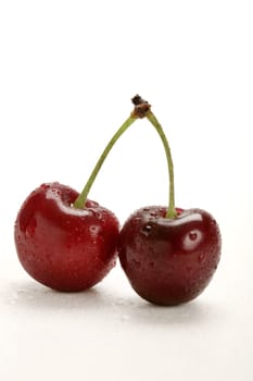 two fresh cherries with water drops