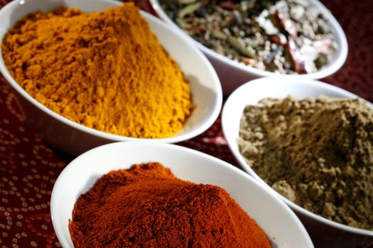 diferent spices in white bowls