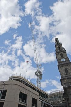 A Construction Site Crane and an Old Clocktower