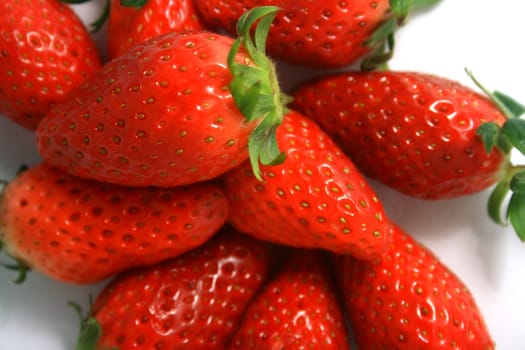 Close-up of brightly red strawberries on a white background.