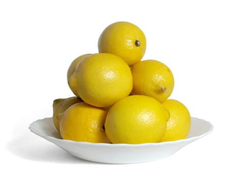 Hill of lemons on a white plate, on a white background