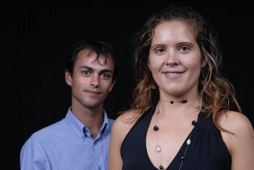 young couple together portrait on black background