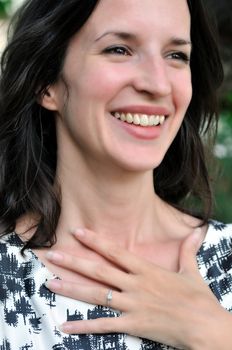 Beautiful young woman smiles with pleasure at receiving an engagement ring.