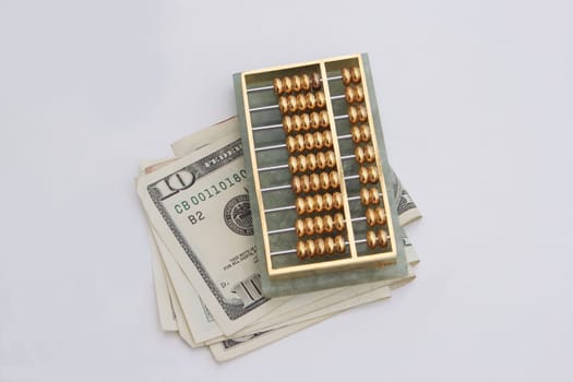 fold of dollars under an abacus