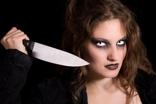 Scary woman holding out a knife as if ready to stab someone