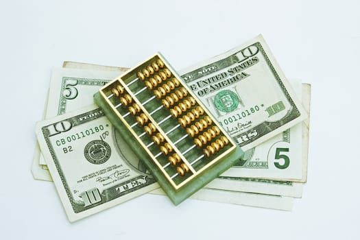 dollars under an abacus paper weight