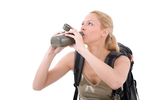 Pretty blond girl in travel outfit taking a drink from her bottle