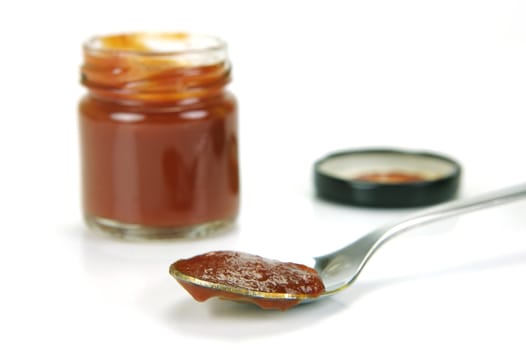 A small jar of ketchup isolated against a white background