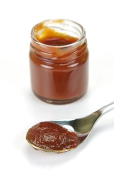 A small jar of ketchup isolated against a white background