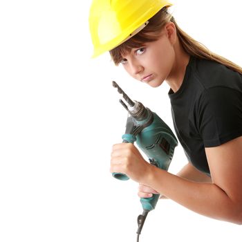 Young woman builder in yellow helmet holding driller