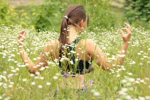 A young woman doing yoga outside in natural environment