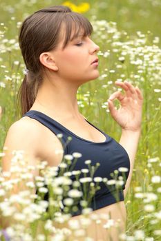 A young woman doing yoga outside in natural environment