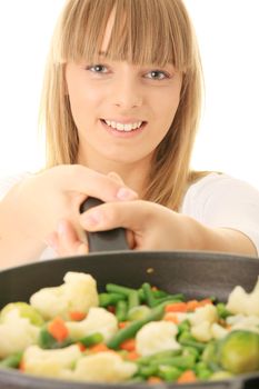 Image of a young woman cooking healthy food in the kitchen