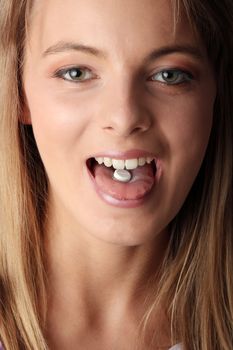 Young woman eating a pill