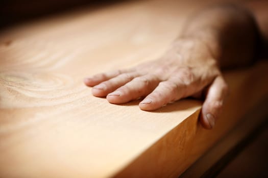 male hand touching a piece of wood