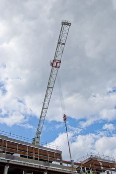 The Jib of a white Construction Crane on a shopping mall site