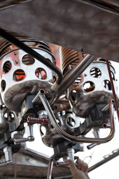 pilot manning the controls of a hot air balloon engine and jets during flight, portrait, tight crop and headline space