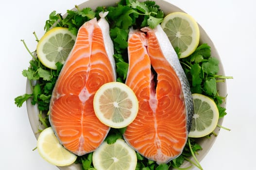 Fresh Salmon steak pieces decorated with lemon and cilantro