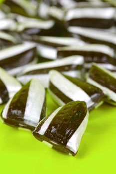 Humbug lollies isolated against a yellow background