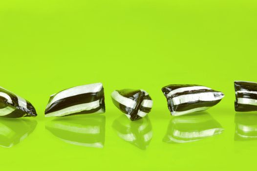 Humbug lollies isolated against a yellow background