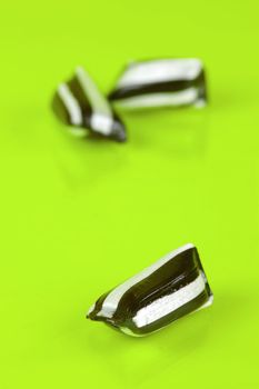 Humbug lollies isolated against a yellow background