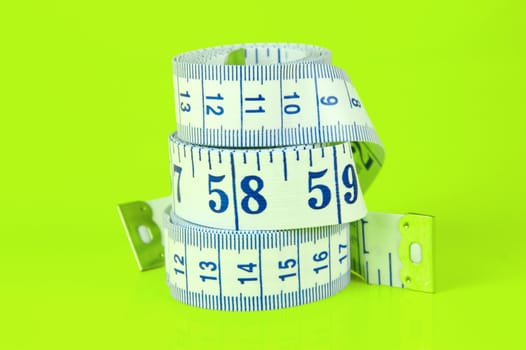 A measuring tape isolated agaist a lime green background