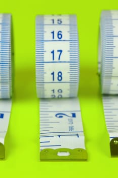 A measuring tape isolated agaist a lime green background