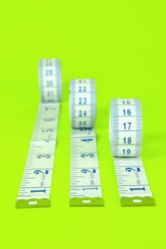 A measuring tape isolated agaist a lime green background