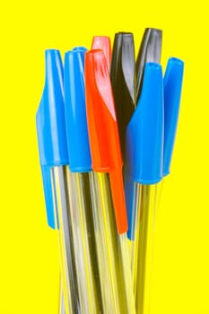 Ball point pens isolated against a yellow background