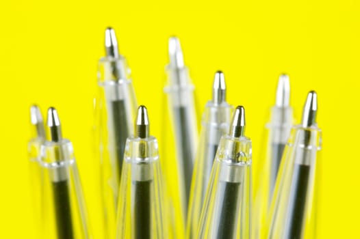 Ball point pens isolated against a yellow background