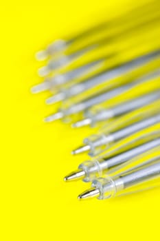 Ball point pens isolated against a yellow background
