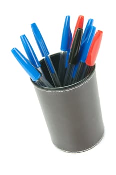 Ball point pens in a cup holder isolated against a white background