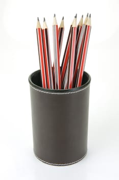 Lead pencils in a cup holder isolated against a white background