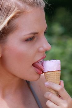 Portrait of young happy woman eating ice-cream, outdoor