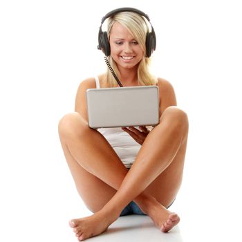 Casual student listening to music on the computer while studying isolated over a white background
